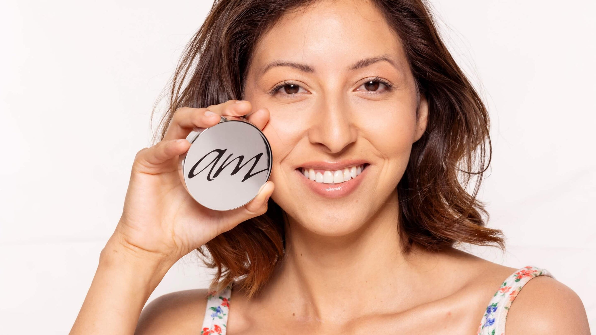 A woman holding up a makeup product.