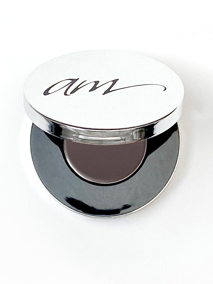 The top view of an advanced mineral makeup compact with powder contents in the color of 'caviar' and the lid half way off. #colour_caviar