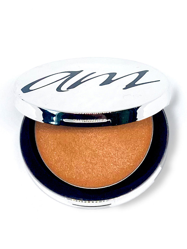 The top view of an advanced mineral makeup product with orange contents and the lid half way off. #colour_peach