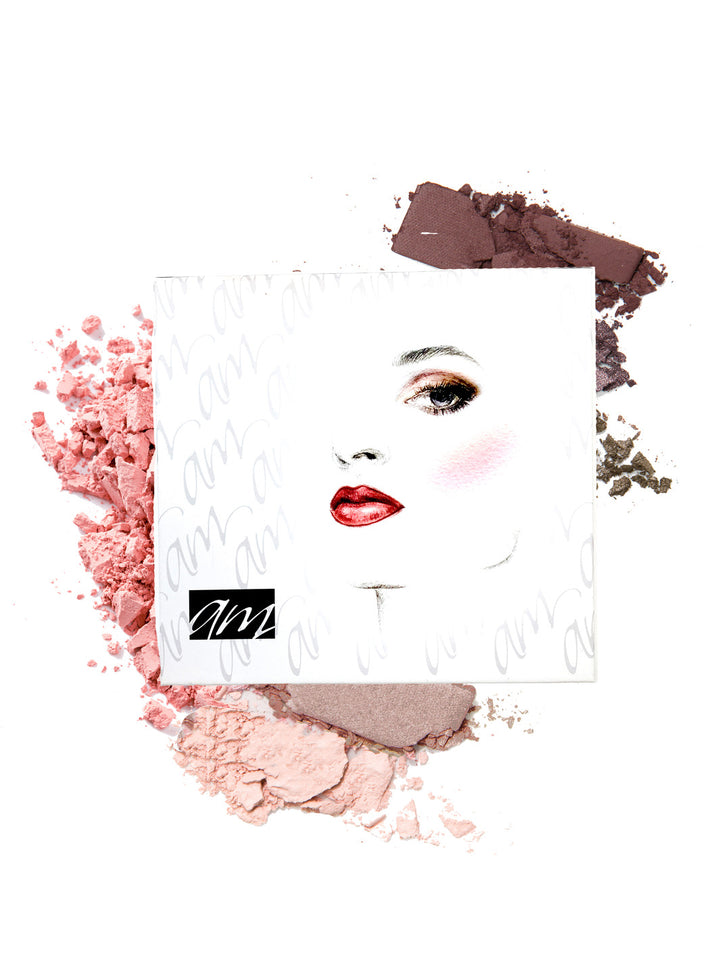 A stylized picture of a woman wearing red lipstick on a square photo laying on two colors of powdered makeup all on a white background.