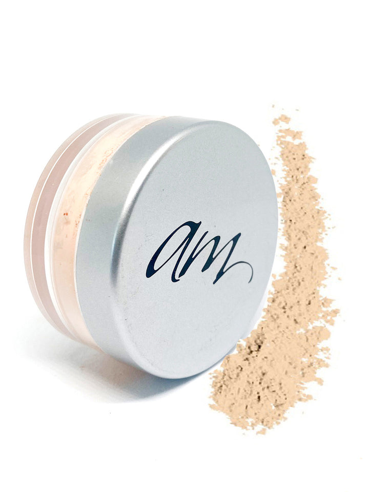 Advanced Mineral makeup loose foundation powder in a small cylinder with yellow powder next to it on a white background. #colour_taylor